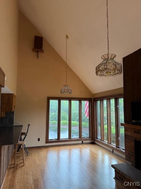 2033 Artemis Dr, Virgil, NY 13045 - living area with high vaulted ceiling, wood finished floors, and a fireplace