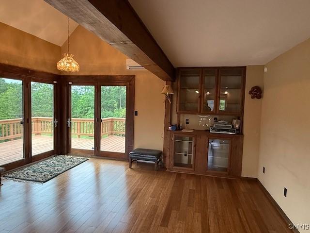 2033 Artemis Dr, Virgil, NY 13045 - bar featuring healthy amount of natural light, wood finished floors, a chandelier, vaulted ceiling, and an AC wall unit