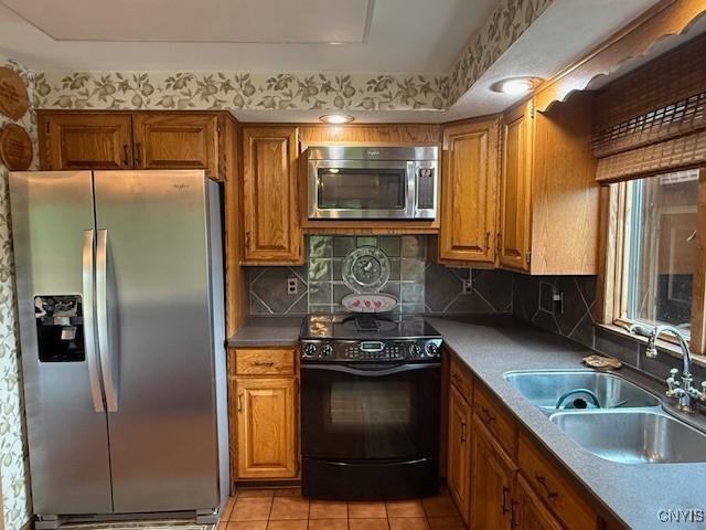 2033 Artemis Dr, Virgil, NY 13045 - kitchen with appliances with stainless steel finishes, brown cabinetry, tasteful backsplash, and light tile patterned floors