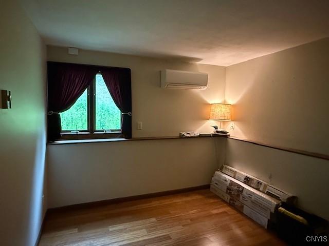 2033 Artemis Dr, Virgil, NY 13045 - unfurnished room with a wall mounted air conditioner and wood finished floors