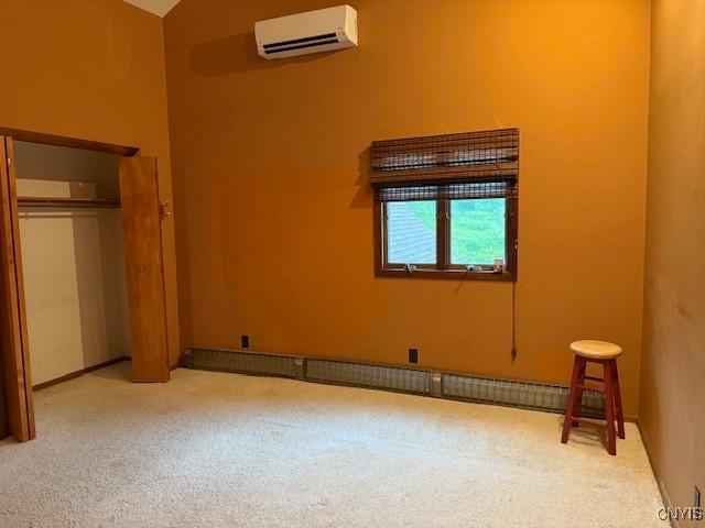 2033 Artemis Dr, Virgil, NY 13045 - unfurnished bedroom featuring an AC wall unit, carpet floors, vaulted ceiling, and a closet