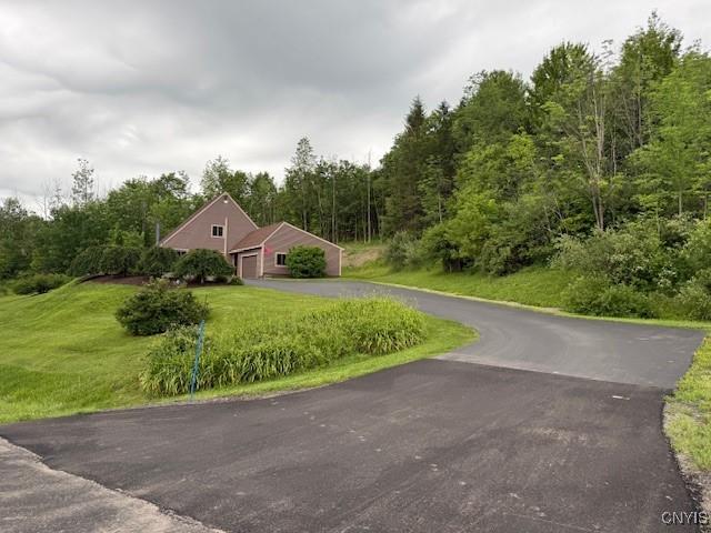 2033 Artemis Dr, Virgil, NY 13045 - view of side of property featuring asphalt driveway, a garage, a yard, and a wooded view