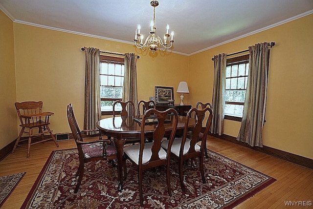 57 Dudley Ave, Hamburg, NY 14075 - dining area featuring a chandelier, ornamental molding, wood finished floors, and healthy amount of natural light