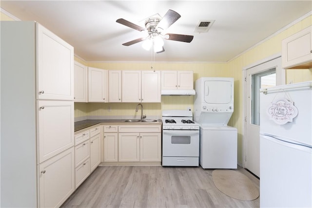 21 Twin Dr, North Dansville, NY 14437 - kitchen featuring white appliances, stacked washer / dryer, under cabinet range hood, a ceiling fan, and light wood-style flooring