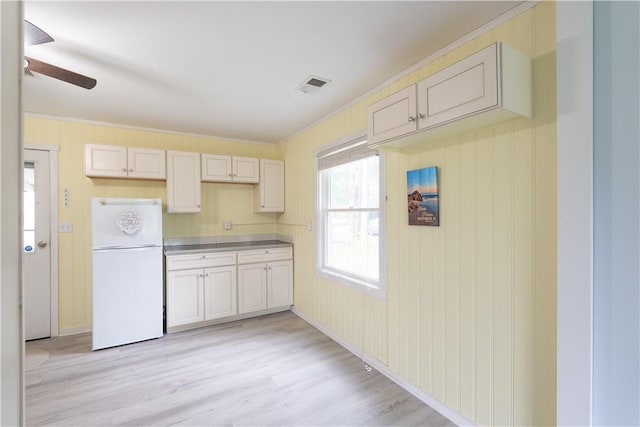 21 Twin Dr, North Dansville, NY 14437 - kitchen featuring freestanding refrigerator, ceiling fan, ornamental molding, light wood-style flooring, and wood walls