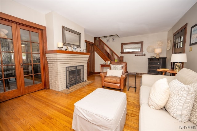 128 Argonne Dr, Tonawanda, NY 14217 - living room with wood finished floors, a brick fireplace, and stairs