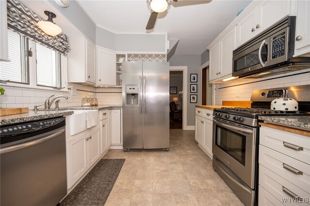 128 Argonne Dr, Tonawanda, NY 14217 - kitchen with appliances with stainless steel finishes, a ceiling fan, decorative backsplash, and open shelves