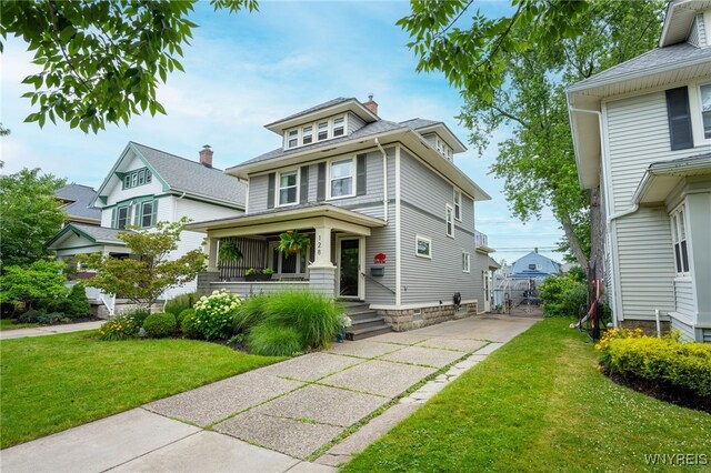 128 Argonne Dr, Tonawanda, NY 14217 - american foursquare style home featuring a front yard, covered porch, and driveway