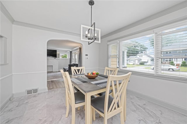 111 Hartsdale Rd, Irondequoit, NY 14622 - dining area featuring marble look tile flooring, a chandelier, arched walkways, and ornamental molding