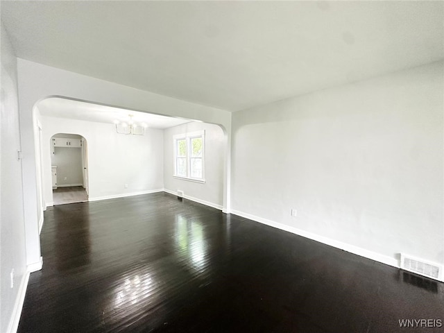 169 Davidson Ave, Buffalo, NY 14215 - empty room featuring arched walkways, a chandelier, and dark wood finished floors