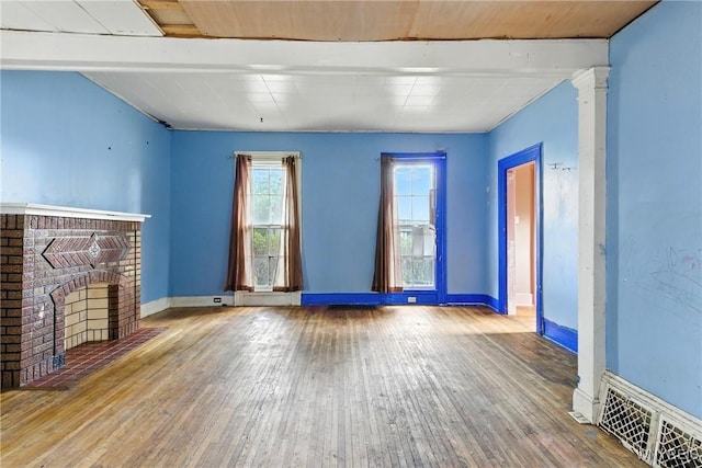 349 Willow St, Lockport City, NY 14094 - unfurnished living room featuring a brick fireplace and hardwood / wood-style floors