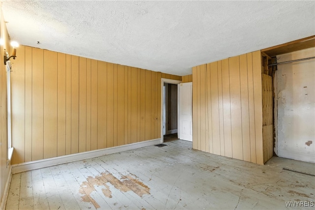 349 Willow St, Lockport City, NY 14094 - unfurnished bedroom with a textured ceiling and wood walls