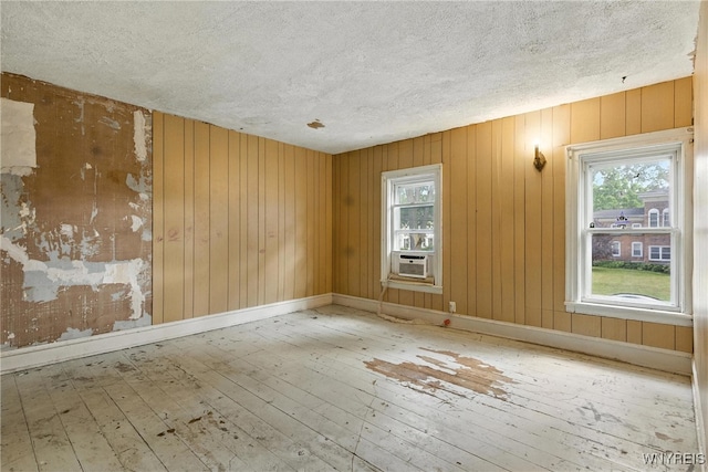 349 Willow St, Lockport City, NY 14094 - unfurnished room featuring a textured ceiling, hardwood / wood-style floors, healthy amount of natural light, wood walls, and cooling unit