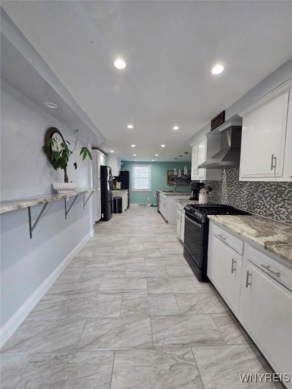 207 Shetland Dr, Amherst, NY 14221 - kitchen featuring black gas stove, wall chimney exhaust hood, white cabinets, recessed lighting, and tasteful backsplash