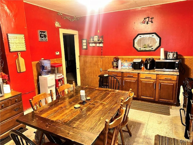 41 Owego St, Cortland, NY 13045 - dining space with a wainscoted wall, tile patterned floors, and wood walls
