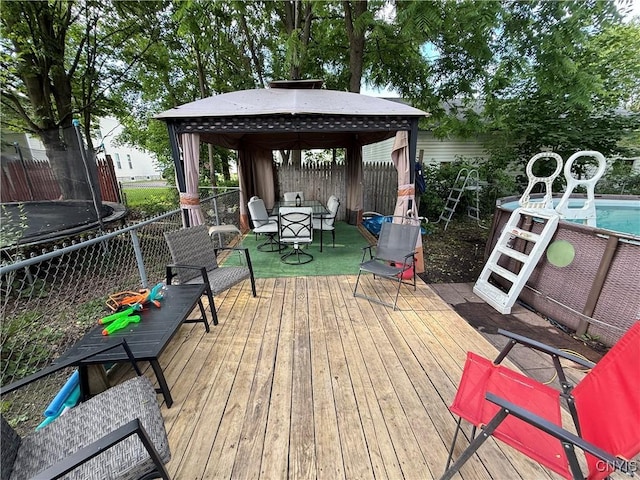 41 Owego St, Cortland, NY 13045 - wooden deck with a trampoline, a gazebo, outdoor dining space, and a fenced backyard