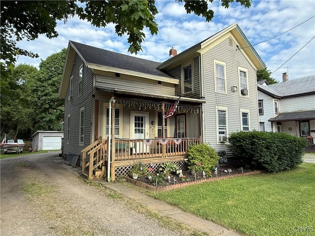 41 Owego St, Cortland, NY 13045 - view of front facade featuring covered porch, an outbuilding, a chimney, a front lawn, and a garage