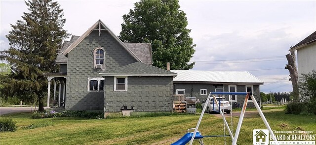 4604 W Railroad Ave, Stockton, NY 14874 - rear view of property featuring a playground, a yard, a shingled roof, and a detached carport