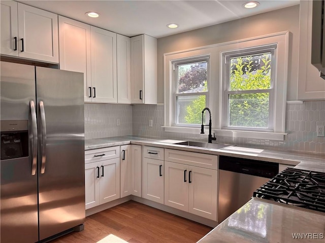 575 Willow Ave, North Tonawanda, NY 14120 - kitchen featuring stainless steel appliances, white cabinetry, light wood-type flooring, recessed lighting, and tasteful backsplash