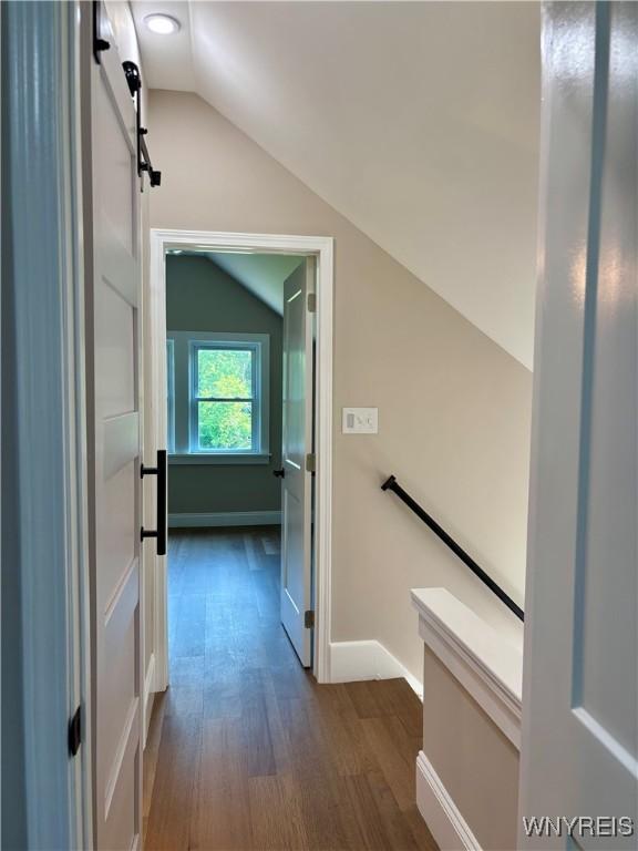 575 Willow Ave, North Tonawanda, NY 14120 - corridor featuring vaulted ceiling, an upstairs landing, dark wood-style floors, and a barn door