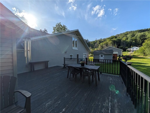 15 Clark Dr, Otto Twp, PA 16745 - wooden terrace with outdoor dining space, a lawn, and an outbuilding