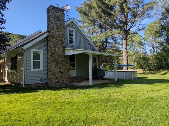 15 Clark Dr, Otto Twp, PA 16745 - rear view of property featuring a chimney, a patio area, and a yard