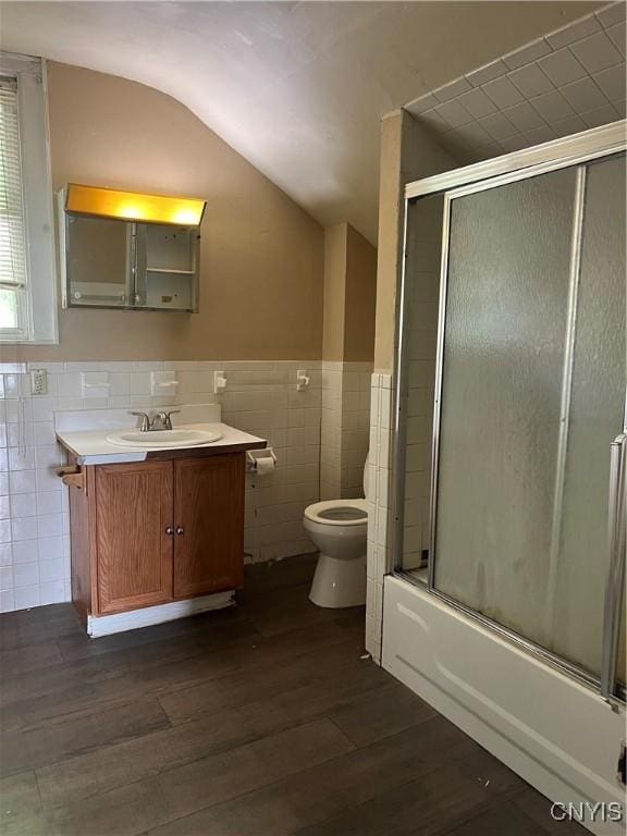 322 N Beech St, Syracuse, NY 13203 - full bath with tile walls, vanity, wood finished floors, lofted ceiling, and shower / bath combination with glass door