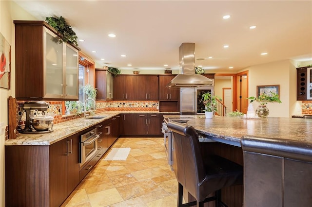 42 Lake Lacoma Dr, Perinton, NY 14534 - kitchen with island exhaust hood, decorative backsplash, recessed lighting, stainless steel appliances, and a breakfast bar