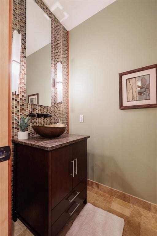 42 Lake Lacoma Dr, Perinton, NY 14534 - bathroom featuring vanity, tasteful backsplash, lofted ceiling, and stone finish floors