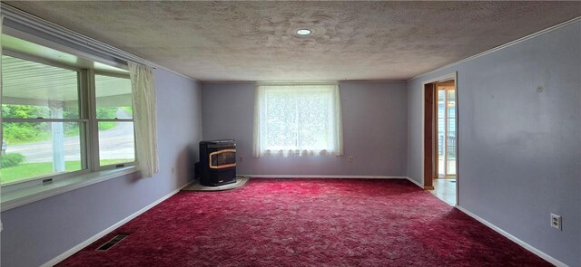 12655 Berwick, Tpke, PA 16925 - carpeted empty room with a wood stove, healthy amount of natural light, ornamental molding, and a textured ceiling