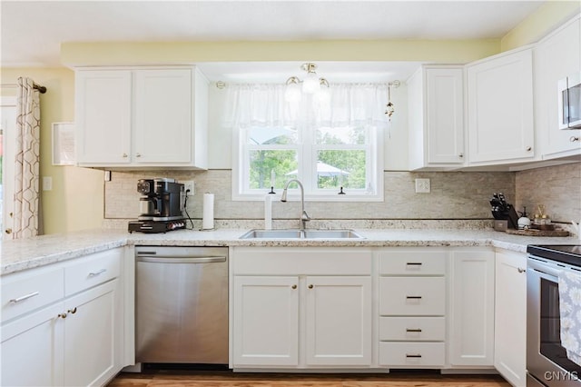 20040 Morin Ln S, Hounsfield, NY 13685 - kitchen featuring stainless steel appliances, white cabinets, tasteful backsplash, and light stone counters