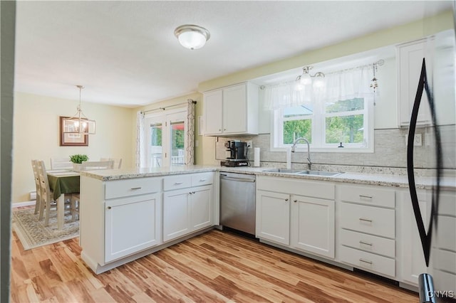 20040 Morin Ln S, Hounsfield, NY 13685 - kitchen featuring stainless steel dishwasher, a peninsula, decorative backsplash, a chandelier, and light wood-type flooring