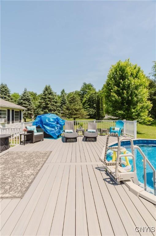 20040 Morin Ln S, Hounsfield, NY 13685 - wooden terrace featuring an outdoor pool and view of wooded area