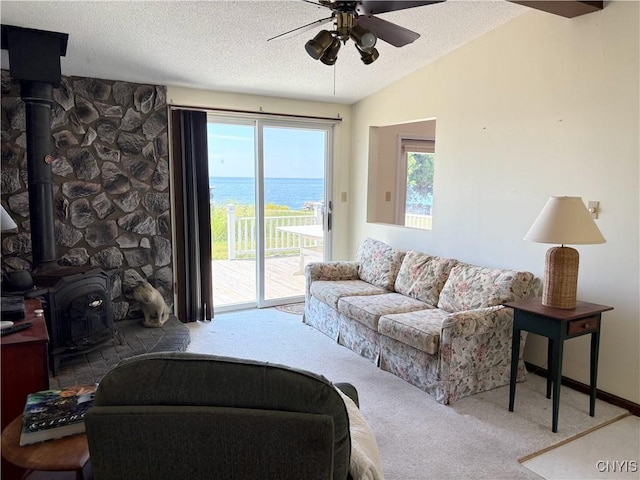 5366 Clark Point Rd, Henderson, NY 13651 - living room featuring a wood stove, carpet flooring, a ceiling fan, a textured ceiling, and a water view