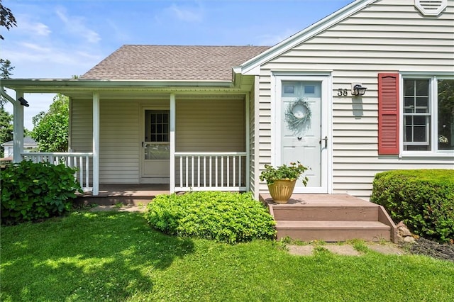 38 Tobin Rd, Henrietta, NY 14467 - view of exterior entry featuring a lawn, covered porch, and a shingled roof