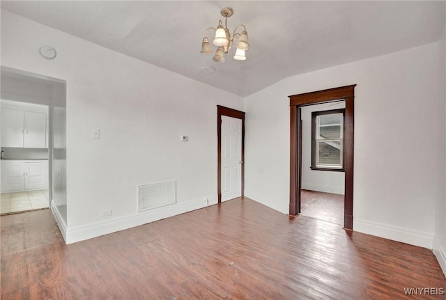 214 Ludington St, Buffalo, NY 14206 - spare room featuring a chandelier and wood finished floors