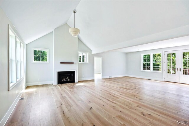 3745 Fisher Rd, Skaneateles, NY 13152 - unfurnished living room featuring light wood-type flooring, healthy amount of natural light, lofted ceiling, a fireplace, and french doors