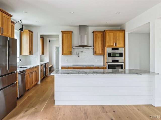 3745 Fisher Rd, Skaneateles, NY 13152 - kitchen featuring appliances with stainless steel finishes, wall chimney exhaust hood, light stone counters, tasteful backsplash, and recessed lighting