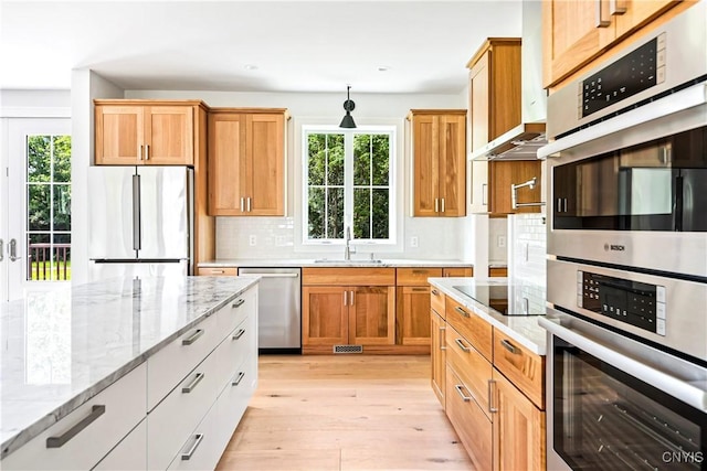3745 Fisher Rd, Skaneateles, NY 13152 - kitchen with appliances with stainless steel finishes, light wood finished floors, light stone counters, decorative backsplash, and recessed lighting