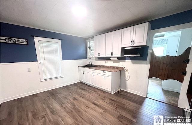 1504 River St, Olean, NY 14760 - kitchen with white cabinetry, healthy amount of natural light, dark wood finished floors, a wainscoted wall, and dark countertops