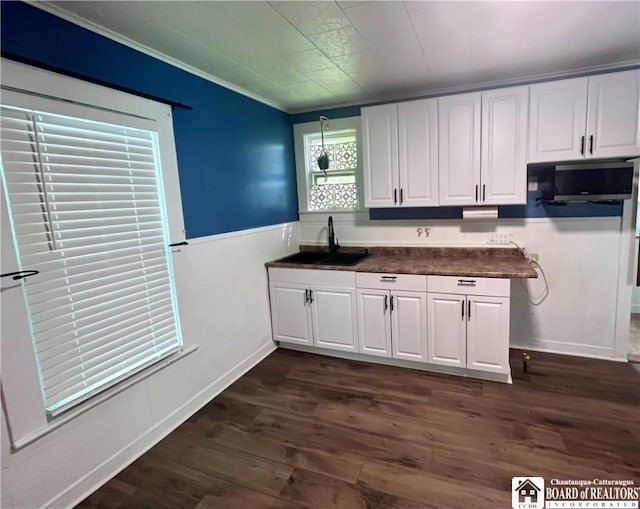 1504 River St, Olean, NY 14760 - kitchen featuring white cabinetry, dark wood-style floors, dark countertops, a wainscoted wall, and crown molding