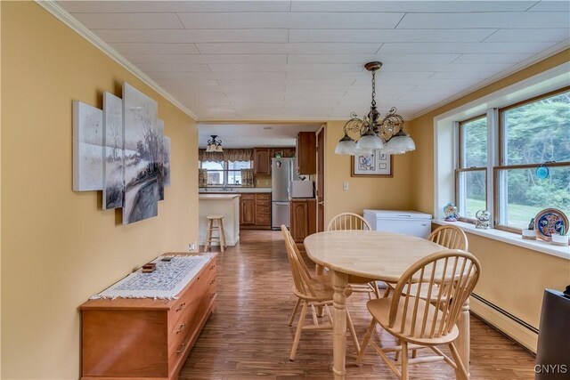 32227 County Route 22, Antwerp, NY 13691 - dining area featuring crown molding, wood finished floors, a chandelier, and baseboard heating