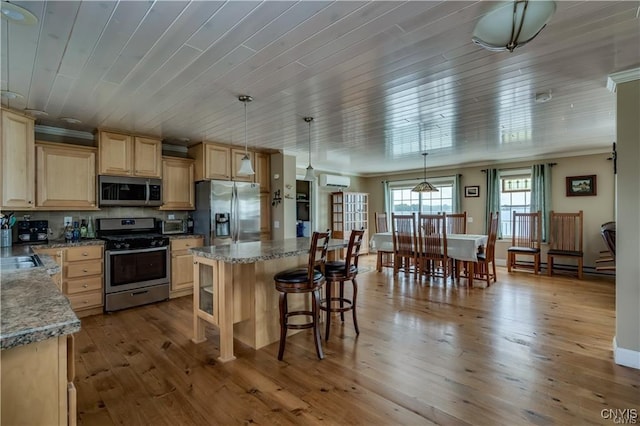 28005/08 Stony Point Rd, Cape Vincent, NY 13618 - kitchen featuring stainless steel appliances, light brown cabinets, a kitchen island, a breakfast bar, and a wall mounted AC