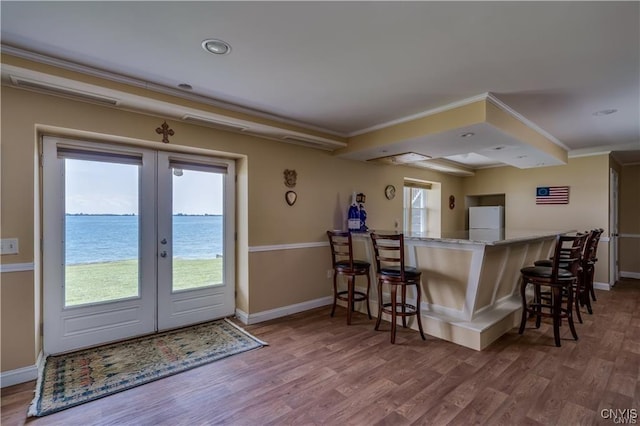 28005/08 Stony Point Rd, Cape Vincent, NY 13618 - kitchen featuring freestanding refrigerator, french doors, wood finished floors, a kitchen breakfast bar, and crown molding