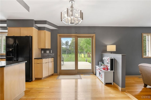 3313 Thompson Rd, Cazenovia, NY 13035 - kitchen with black fridge, light brown cabinets, dark countertops, light wood-style floors, and a chandelier
