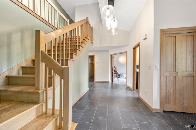 3313 Thompson Rd, Cazenovia, NY 13035 - entrance foyer with high vaulted ceiling, stairway, a chandelier, and dark tile patterned flooring