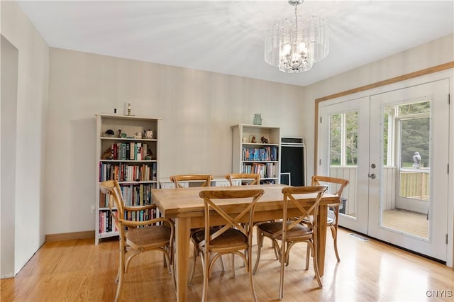 3313 Thompson Rd, Cazenovia, NY 13035 - dining room featuring light wood-style flooring, a chandelier, and french doors