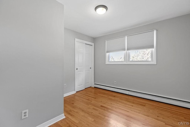 113 Craig Cir, Dewitt, NY 13214 - unfurnished bedroom with a baseboard heating unit, light wood-style floors, and a closet
