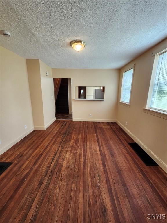 114 Stevens Pl, Syracuse, NY 13210 - spare room featuring hardwood / wood-style flooring, stairway, a textured ceiling, and a smoke detector