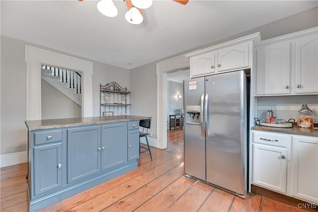6188 Lake St, Aurelius, NY 13034 - kitchen featuring stainless steel fridge with ice dispenser, white cabinets, light wood-style flooring, and blue cabinets